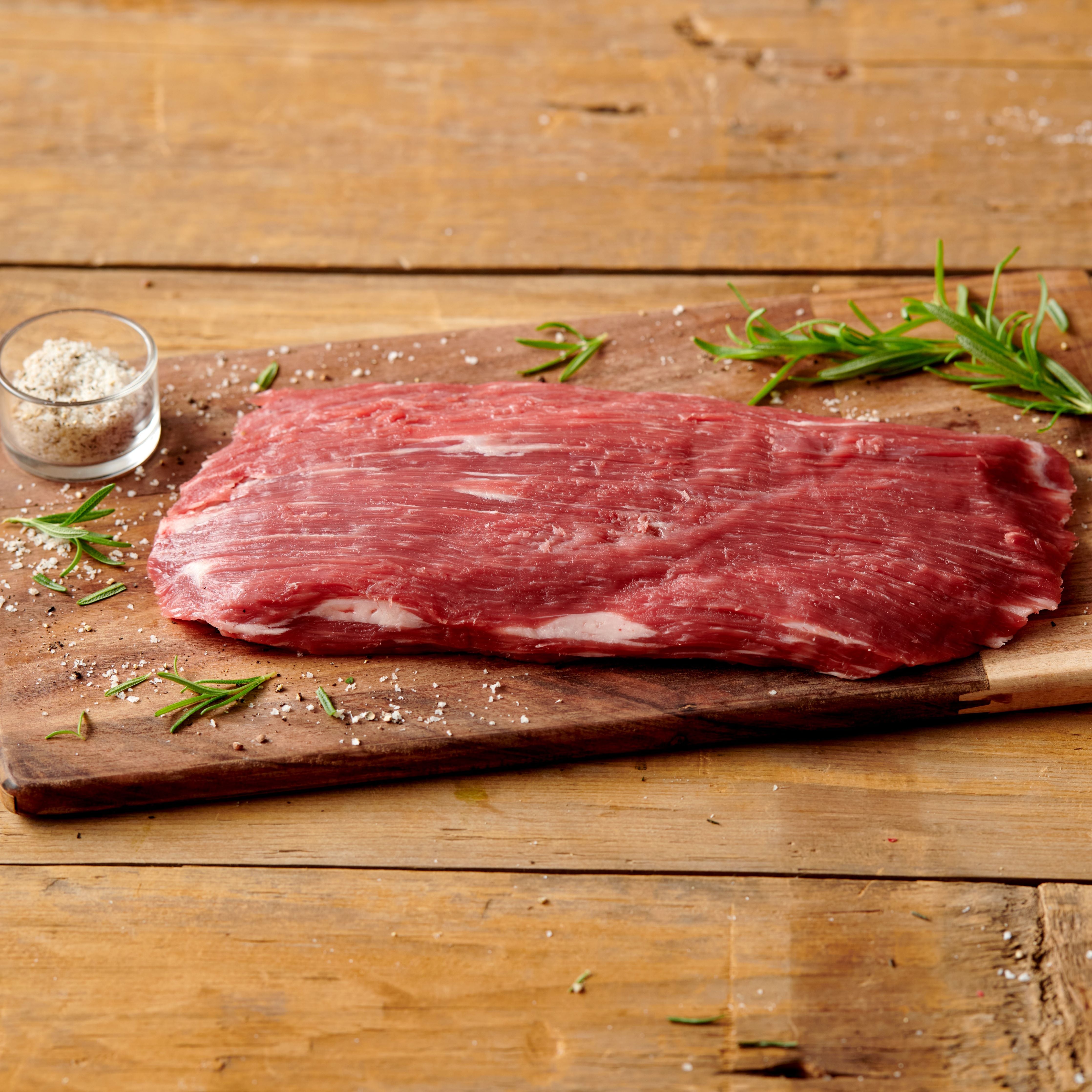 usda choice angus beef flank steak on wooden cutting board